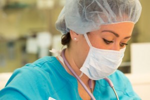 Nurse anesthetist using stethoscope on a patient in surgery