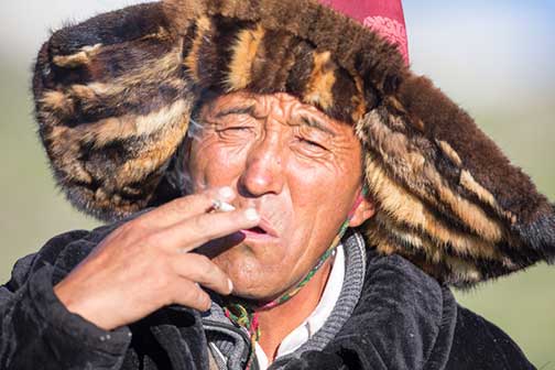 Kazakh nomad of western Mongolia smoking a hand rolled cigarette