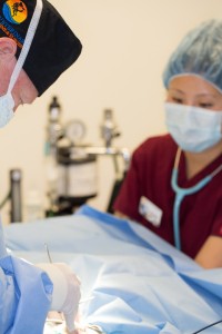 Nurse anesthetist monitoring heart with a stethoscope during surgery